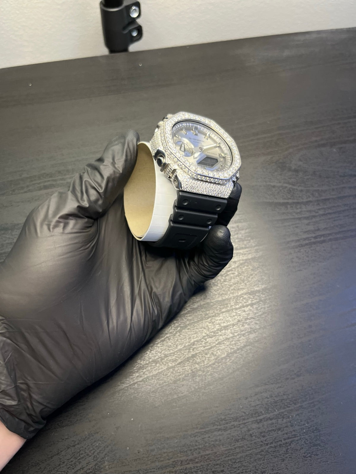 A finished watch checked by hand in a nitrile glove
